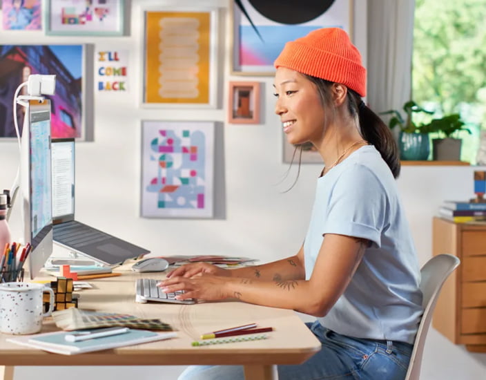 Kvinde foran skrivebord med Logitech MX Keys Mini Wireless tastatur