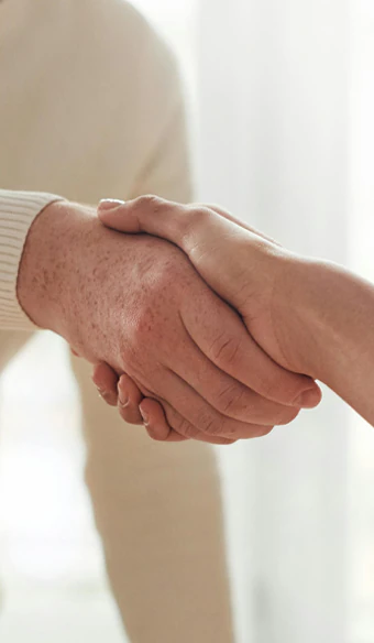 2 personer der giver hånd